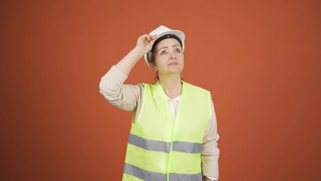 Looking-up,-the-engineer-is-holding-her-hard-hat.